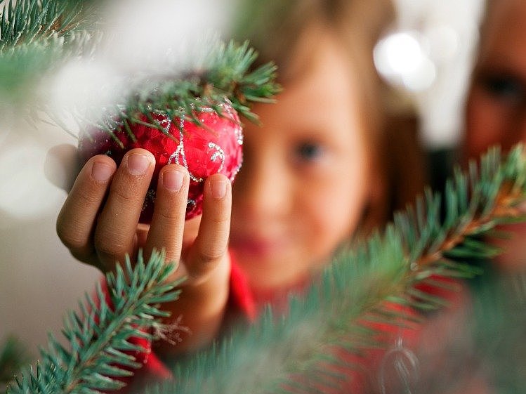 Kleines Kind im Hintergrund eines Weihnachtsbaumes
